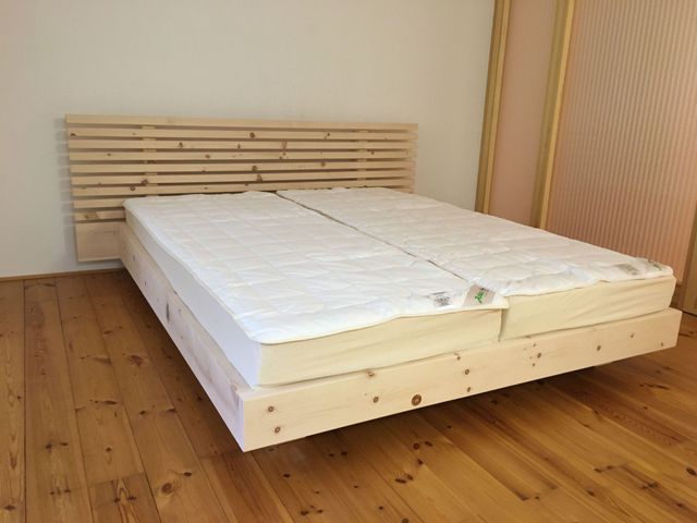 Filigranes Zirbenbett mit Kopfteil in Bretteroptik. 